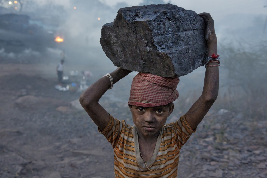 ROBB KENDRICK/National Geographic Ranchi, Jharkhand, India Un ragazzo trasporta un pezzo di carbone nell'accampamento di minatori in cui vive. 